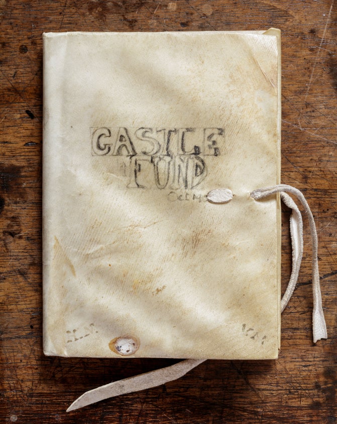 A rectangular notebook with the words 'Castle Fund' and '1913' written on it in pencil